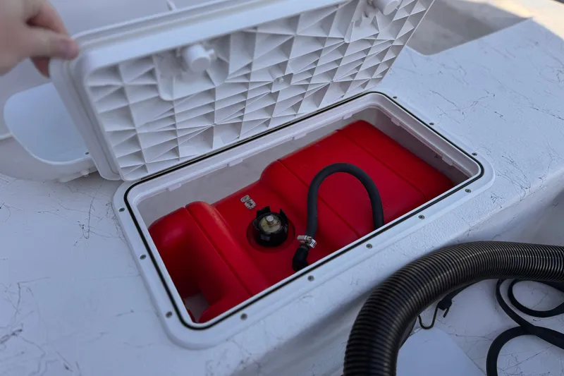 Slide: The Image of Open storage compartment on 2018 Caravelle Key Largo 161 boat, revealing red fuel tank. - 18