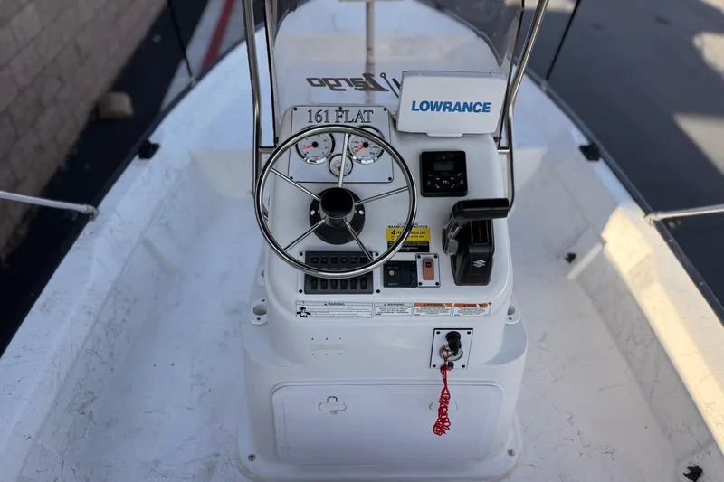 Slide: The Image of 2018 Caravelle Key Largo 161 boat console with steering wheel and navigation equipment. - 21