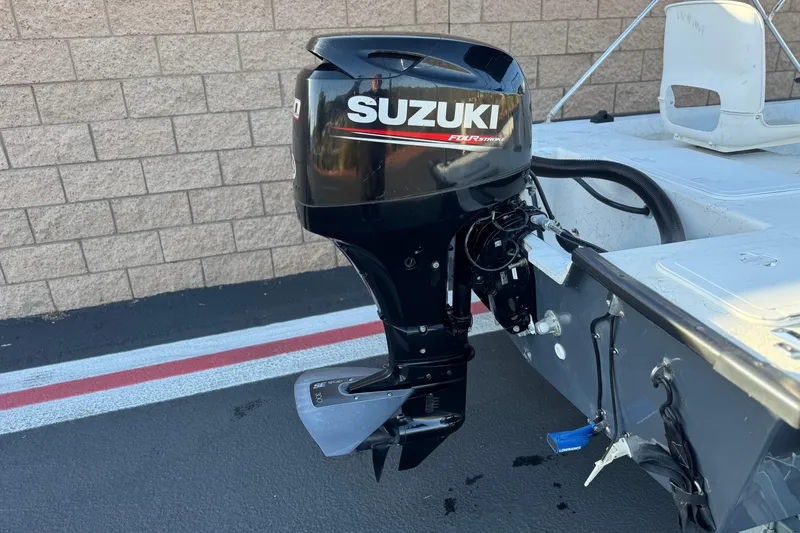 Slide: The Image of 2018 Caravelle Key Largo 161 with Suzuki outboard motor, parked on pavement. - 6