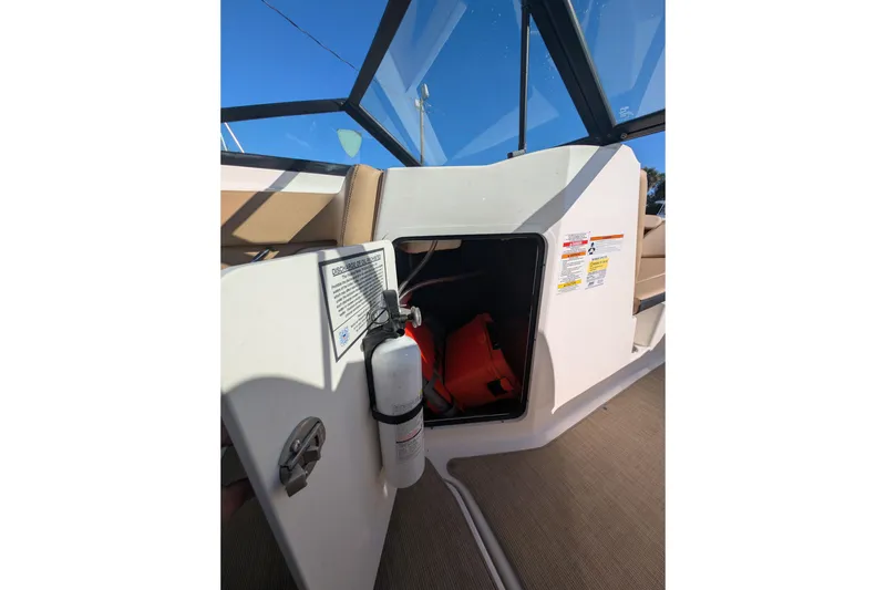 Slide: The Image of Open storage compartment on 2021 Sea Ray 21 SPX OB boat with fire extinguisher and life jackets. - 19