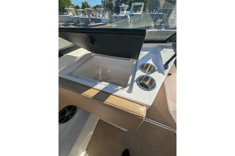 Slide: The Image of 2021 Sea Ray 21 SPX OB boat interior with open storage compartment and cup holders. - 21