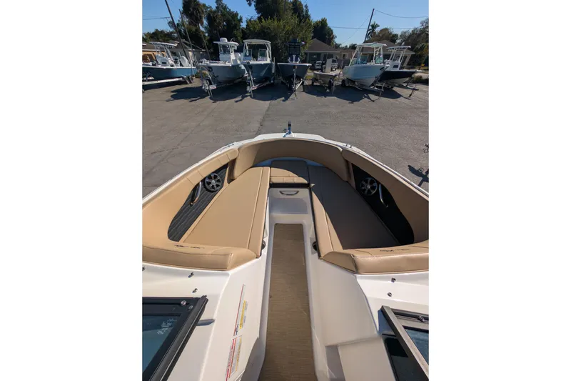 Slide: The Image of 2021 Sea Ray 21 SPX OB boat interior with tan seating, docked among other boats. - 8