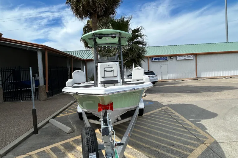 Slide: The Image of 2026 Sea Pro 230 Bay boat on trailer in parking lot, palm tree background. - 2
