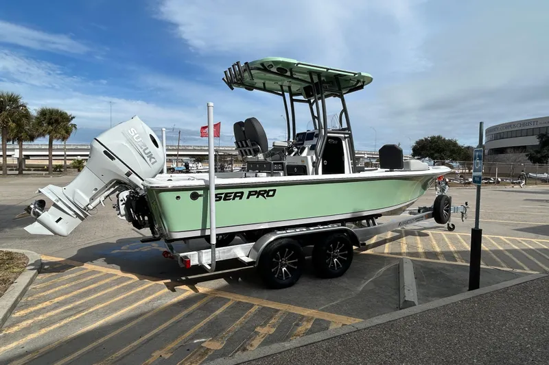 Slide: The Image of 2026 Sea Pro 230 Bay boat on trailer, parked in a lot under a cloudy sky. - 4
