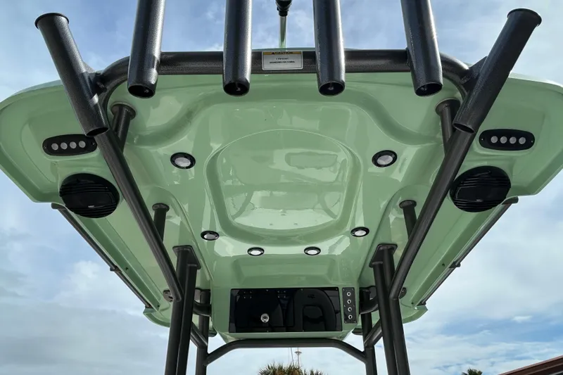 Slide: The Image of 2026 Sea Pro 230 Bay boat T-top with rod holders and speakers, viewed from below. - 9