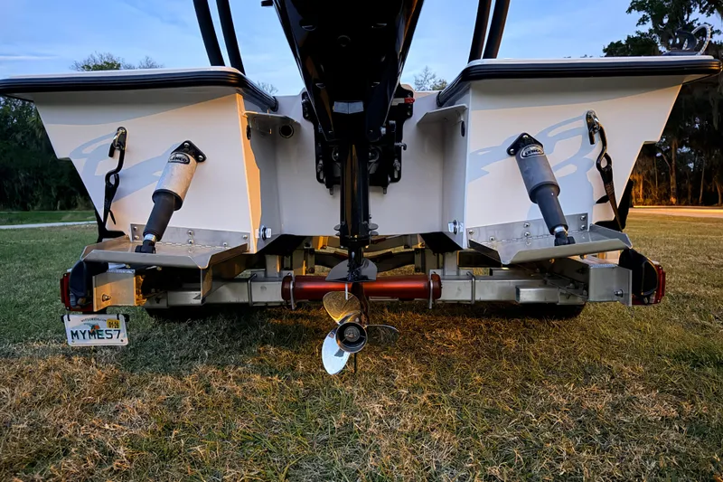 Slide: The Image of Rear view of a 2004 Hell's Bay Devilray boat on a trailer, showcasing propeller and trim tabs. - 11