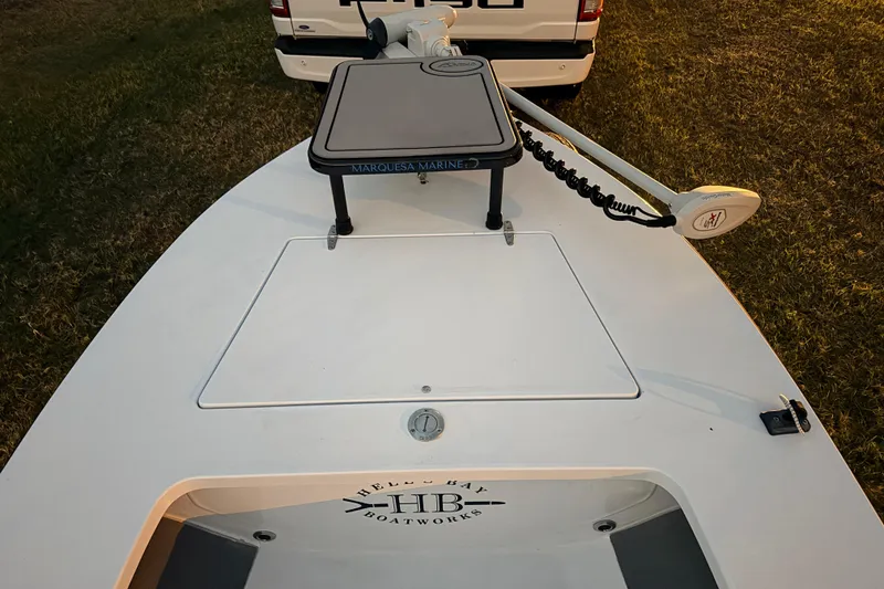 Slide: The Image of 2004 Hell's Bay Devilray boat with trolling motor, parked on grass. - 14