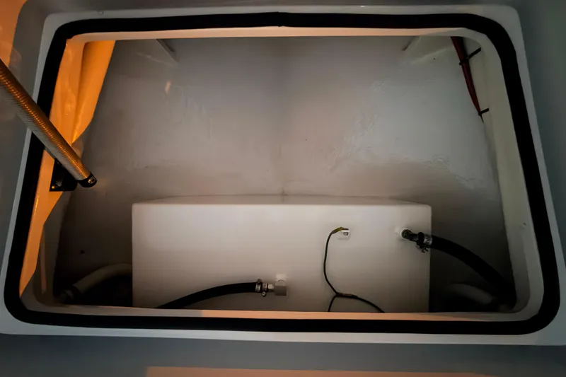 Slide: The Image of 2004 Hell's Bay Devilray boat compartment with storage tank and hoses. - 20