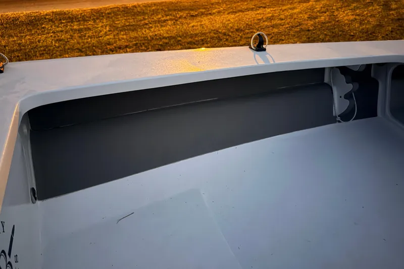 Slide: The Image of 2004 Hell's Bay Devilray boat interior with storage compartment, illuminated by warm sunlight. - 23
