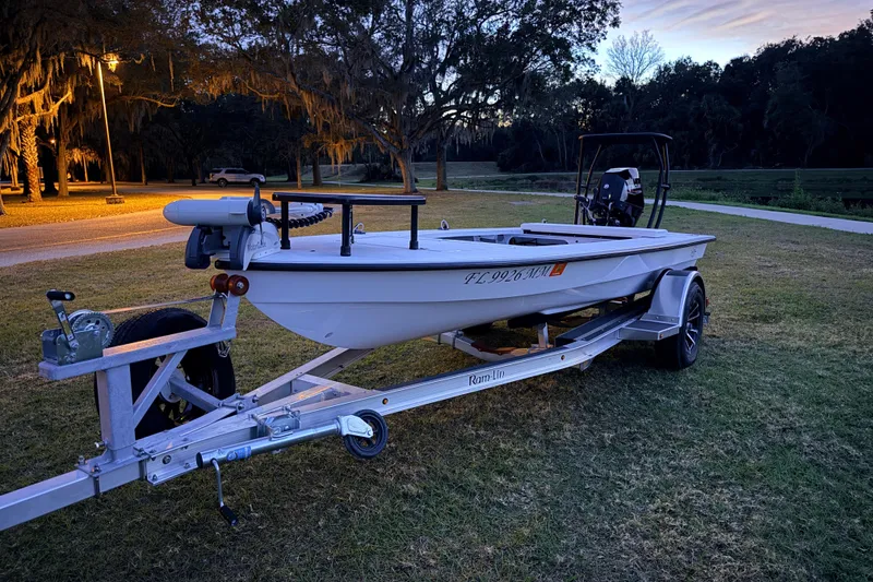 Slide: The Image of 2004 Hell's Bay Devilray boat on trailer at dusk, parked on grass. - 4