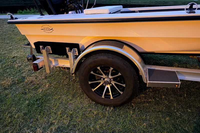 Slide: The Image of 2004 Hell's Bay Devilray boat on trailer, parked on grass. - 9