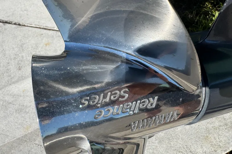 Slide: The Image of 2022 NauticStar 2602 Legacy with dual Yamaha 150 outboard engines, parked outdoors. - 13