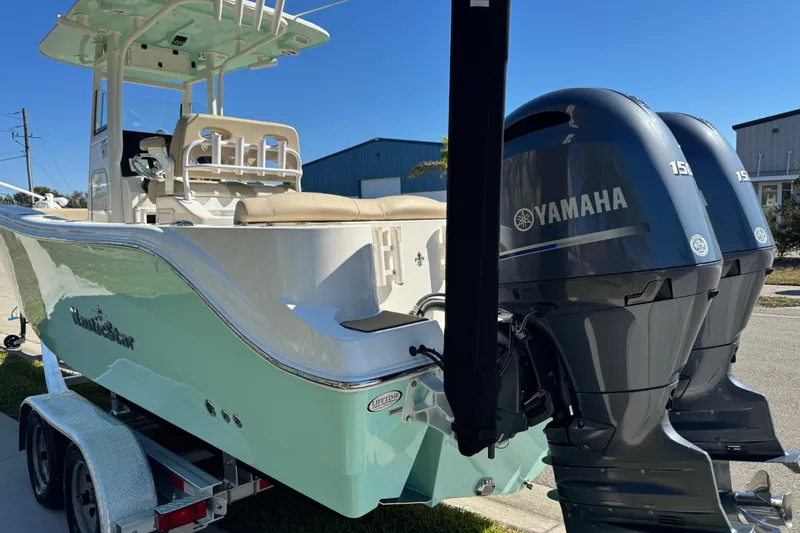 Slide: The Image of 2022 NauticStar 2602 Legacy boat on trailer, sunny day, palm trees in background. - 20