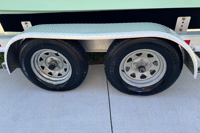 Slide: The Image of 2022 NauticStar 2602 Legacy logo on light green boat exterior. - 22