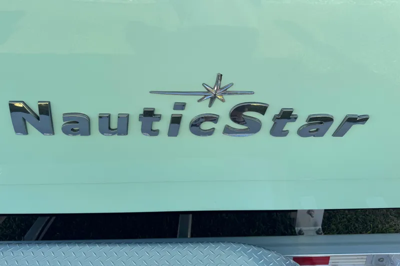 Slide: The Image of 2022 NauticStar 2602 Legacy boat on trailer, side view under clear blue sky. - 23