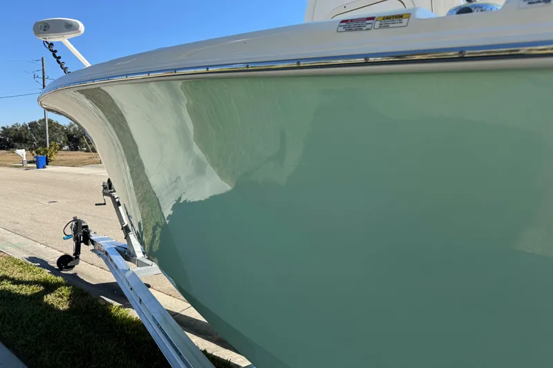 Slide: The Image of 2022 NauticStar 2602 Legacy boat on trailer, parked outdoors under clear sky. - 24