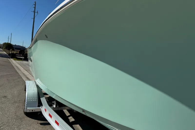 Slide: The Image of 2022 NauticStar 2602 Legacy boat on trailer, side view, light blue hull. - 33