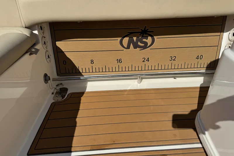 Slide: The Image of Control panel of 2022 NauticStar 2602 Legacy boat with various switches and 12V outlet. - 38