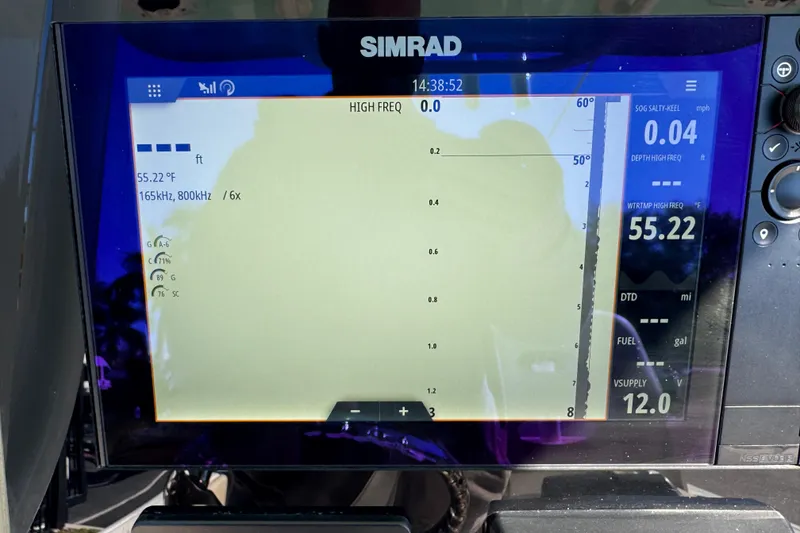 Slide: The Image of 2022 NauticStar 2602 Legacy boat with T-top and rod holders, under clear blue sky. - 53