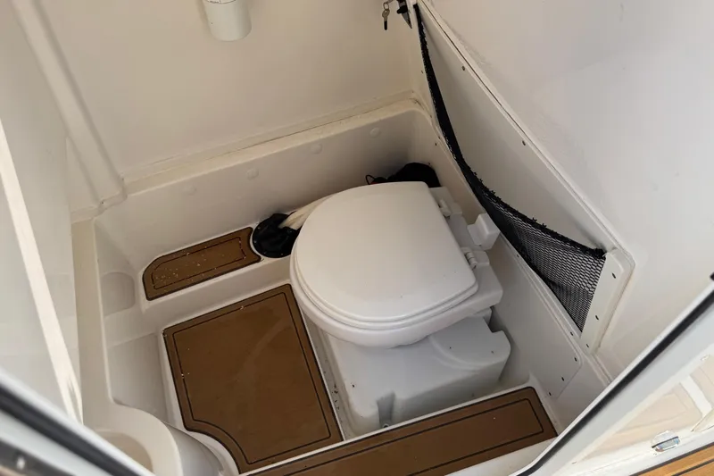 Slide: The Image of 2022 NauticStar 2602 Legacy boat interior with cushioned seating and teak flooring. - 54