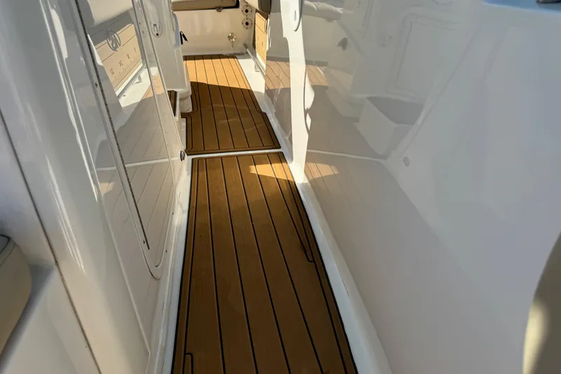 Slide: The Image of 2022 NauticStar 2602 Legacy boat with sleek wooden deck flooring. - 75