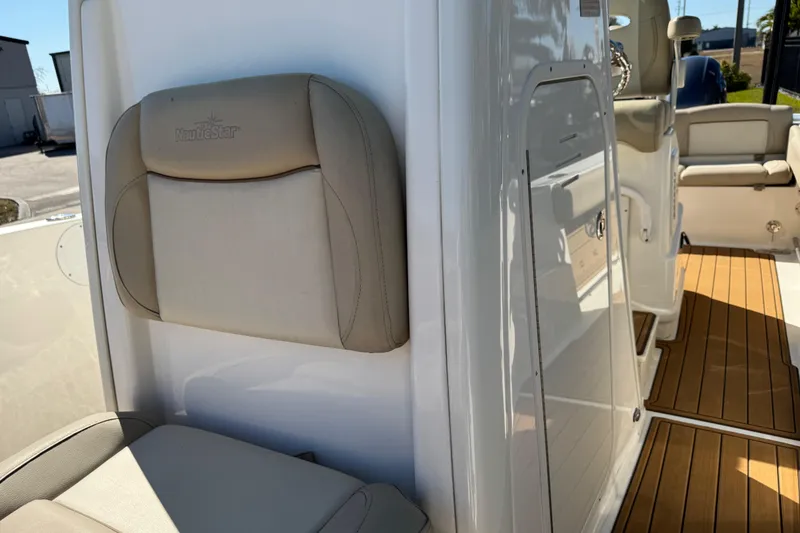Slide: The Image of 2022 NauticStar 2602 Legacy boat interior with cushioned seating and teak flooring. - 76