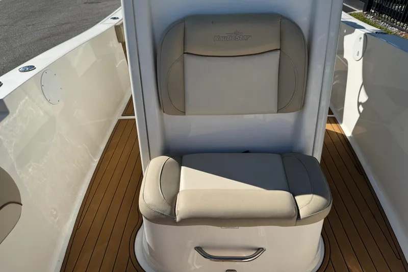 Slide: The Image of 2022 NauticStar 2602 Legacy boat seat with beige cushions and teak flooring. - 77