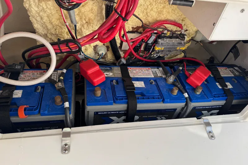 Slide: The Image of Batteries and wiring inside a 2022 NauticStar 2602 Legacy boat compartment. - 81