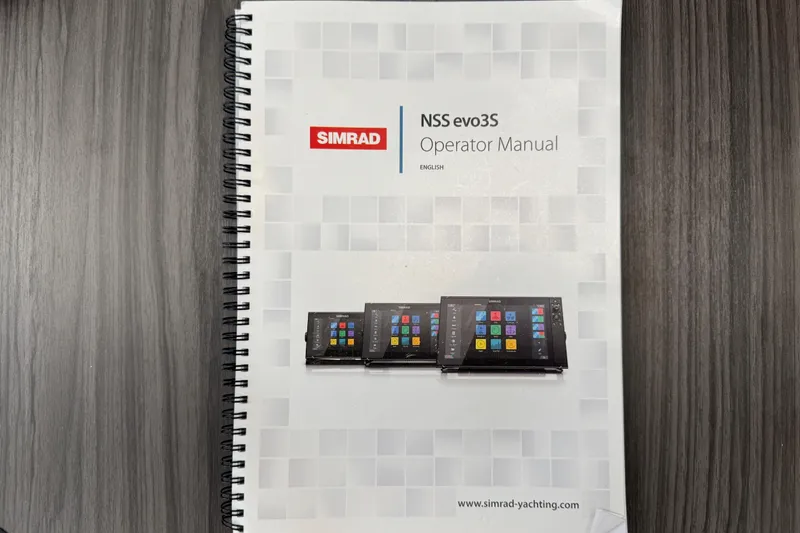 Slide: The Image of Simrad NSS evo3S Operator Manual on a wooden table, spiral-bound. - 98