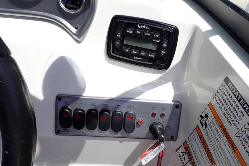 Slide: The Image of Control panel of 2021 NauticStar 223 DC boat with switches and Infinity stereo system. - 12
