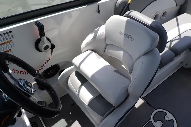Slide: The Image of 2021 NauticStar 223 DC boat interior with steering wheel and cushioned seating. - 14