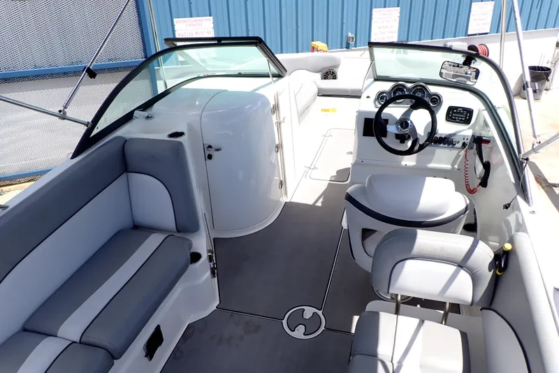 Slide: The Image of 2021 NauticStar 223 DC boat interior with seating, steering wheel, and dashboard. - 3