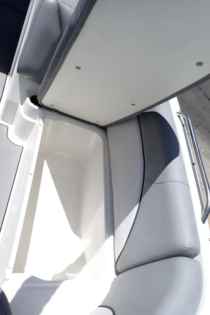 Slide: The Image of 2021 NauticStar 223 DC boat with open storage compartment and cushioned seating. - 35
