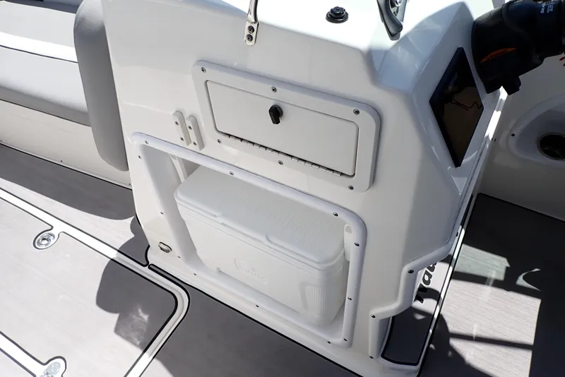Slide: The Image of 2021 NauticStar 223 DC boat interior with storage compartment and cooler. - 42