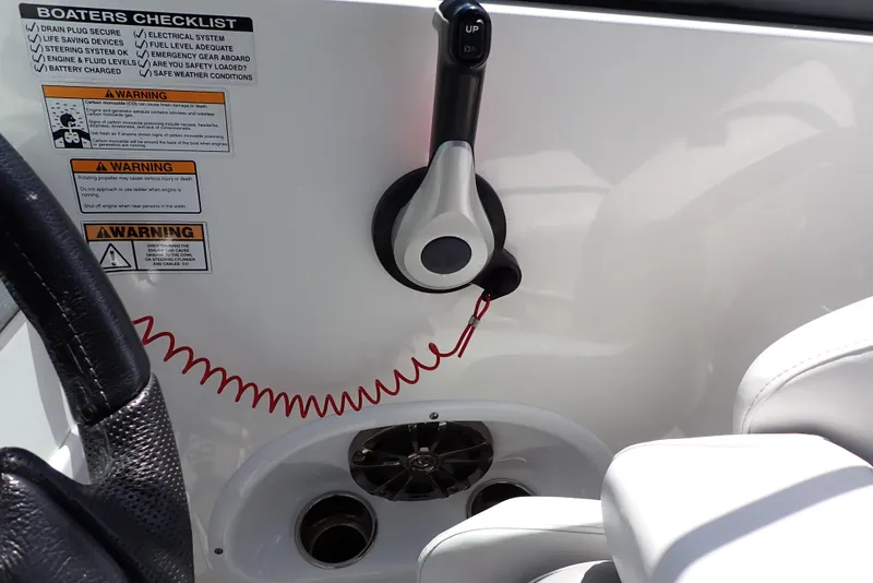 Slide: The Image of Interior controls of 2021 NauticStar 223 DC boat, featuring steering wheel and safety warnings. - 44