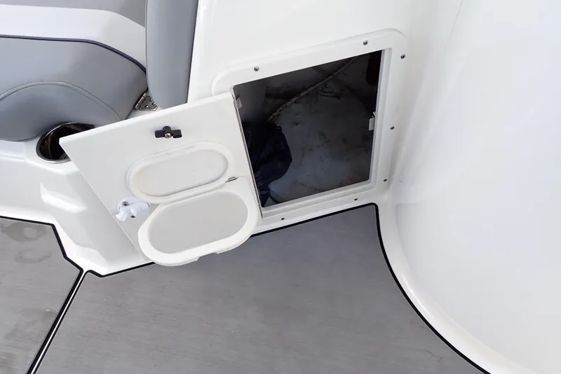 Slide: The Image of Open storage compartment on 2021 NauticStar 223 DC boat with gray seating. - 47