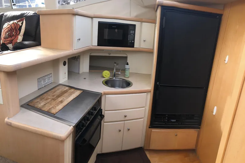 Slide: The Image of 1997 Carver 355 Aft Cabin Motor Yacht kitchen with stove, microwave, and fridge. - 22