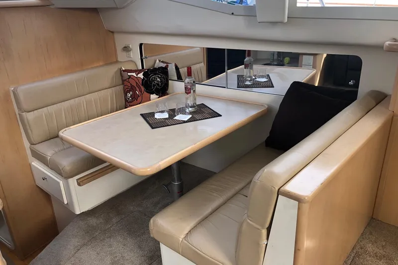 Slide: The Image of 1997 Carver 355 Aft Cabin Motor Yacht interior with beige seating and dining table. - 26