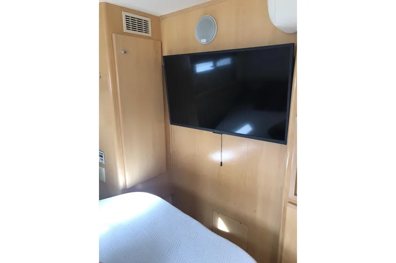 Slide: The Image of 1997 Carver 355 Aft Cabin Motor Yacht interior with mounted TV and wood paneling. - 30