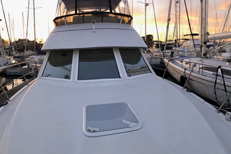 Slide: The Image of 1997 Carver 355 Aft Cabin Motor Yacht docked at sunset, surrounded by sailboats. - 11