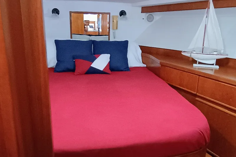Slide: The Image of 1988 Vantare 46' Aft Cabin interior with red bedding and nautical decor. - 26