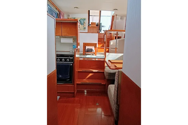 Slide: The Image of Interior of 1988 Vantare 46' Aft Cabin Wide Body MY, featuring wood finishes and compact kitchen. - 30