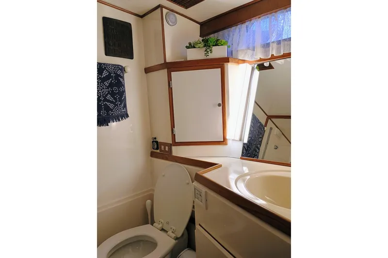 Slide: The Image of 1988 Vantare 46' Aft Cabin yacht bathroom with sink, toilet, and storage cabinet. - 35