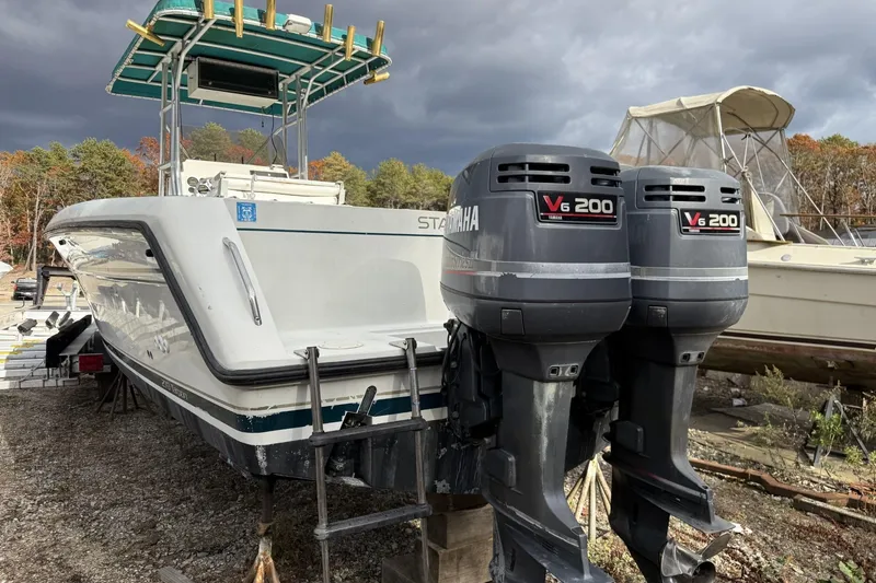 The Image of 1997 Stamas 270 Tarpon boat with twin Yamaha V6 200 engines, docked outdoors. - 0