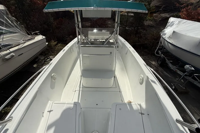 Slide: The Image of 1997 Stamas 270 Tarpon boat with center console and teal canopy, docked outdoors. - 6