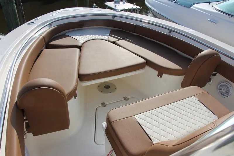 Slide: The Image of 2025 Pioneer 222 Islander boat interior with brown cushioned seating and white accents. - 5
