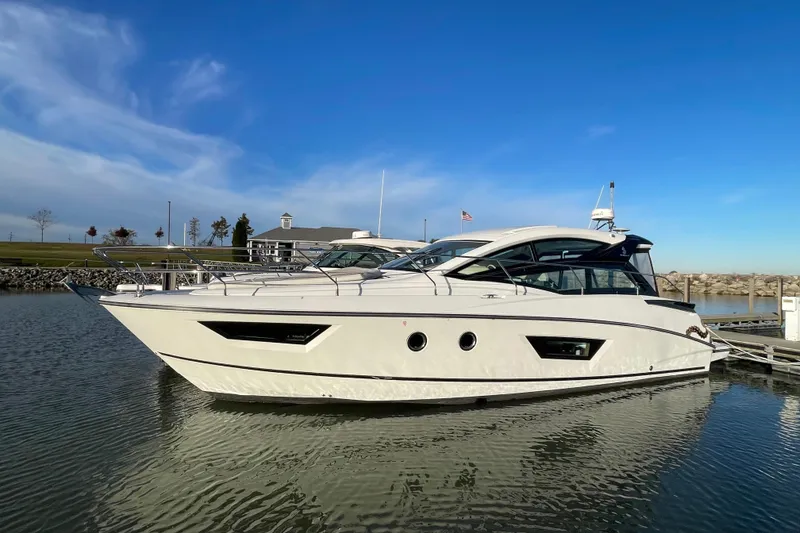 Slide: The Image of 2018 Benetau Gran Turismo 40 yacht docked in a serene marina setting. - 2
