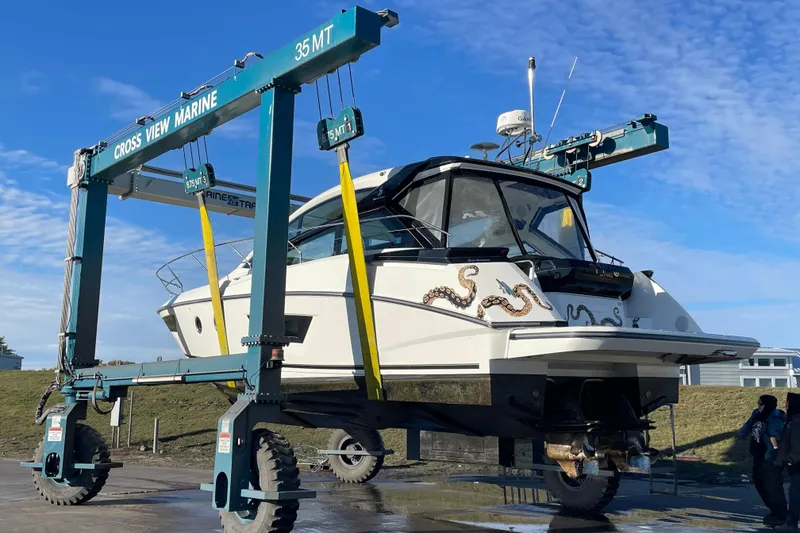 Slide: The Image of 2018 Benetau Gran Turismo 40 yacht lifted by marine crane under blue sky. - 25