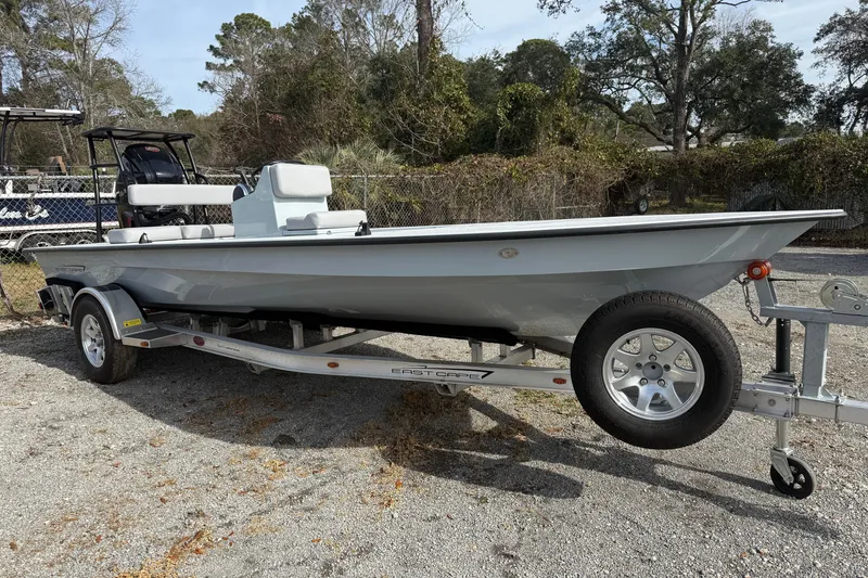 The Image of 2025 East Cape Vantage boat on trailer, parked outdoors, surrounded by trees. - 0