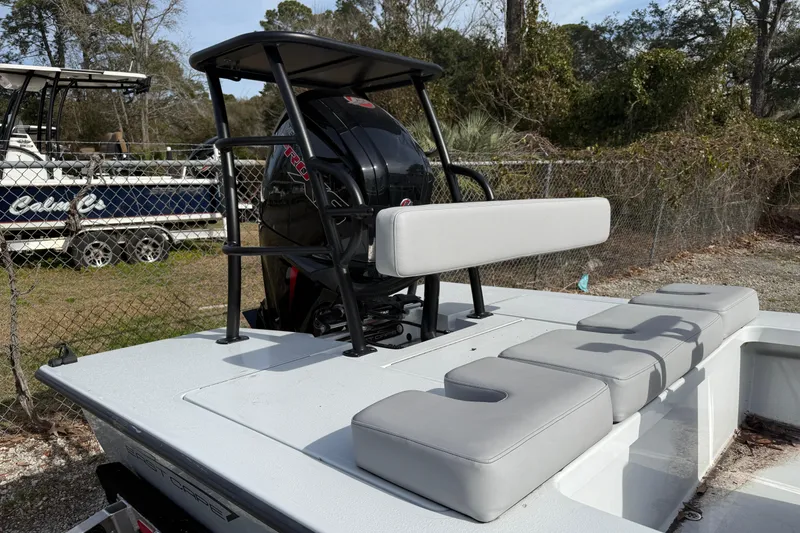 Slide: The Image of 2025 East Cape Vantage boat with cushioned seating and motor, parked outdoors. - 4